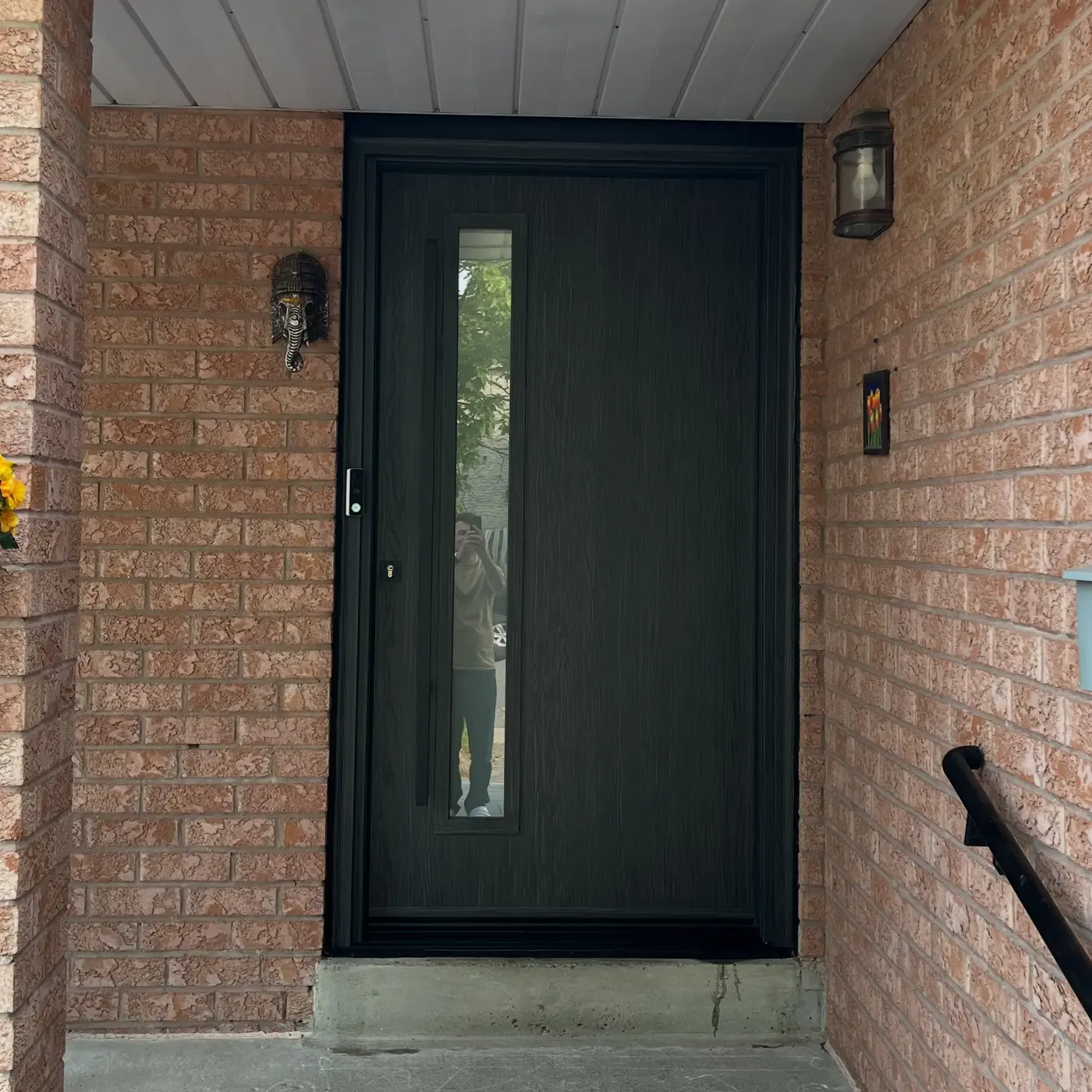 Modern black front door with vertical glass insert on a brick home in Vaughan, Ontario